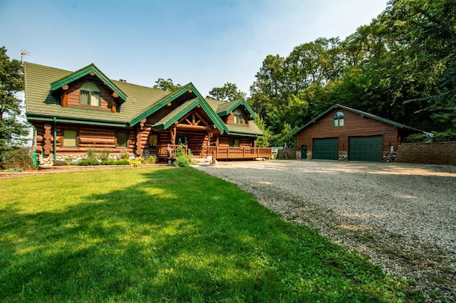 log-style house with a front yard, an outdoor structure, and a garage