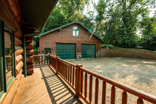 wooden deck with a garage and an outbuilding