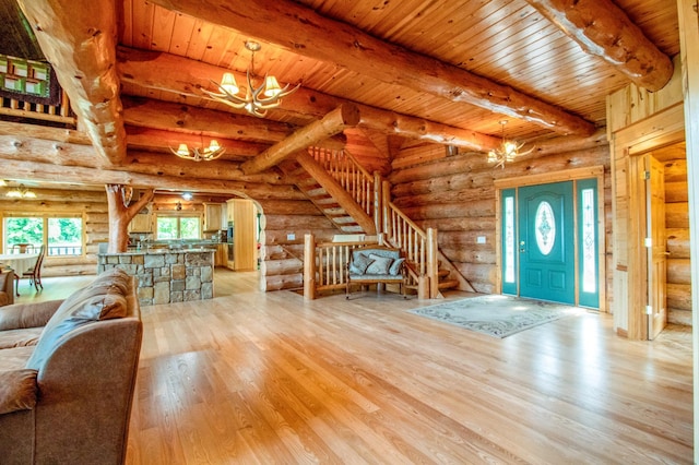 foyer featuring plenty of natural light, log walls, and an inviting chandelier