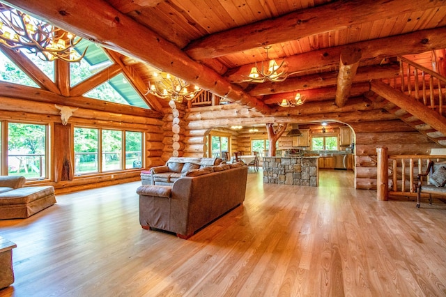 living room with wooden ceiling, a notable chandelier, light wood-type flooring, log walls, and beamed ceiling