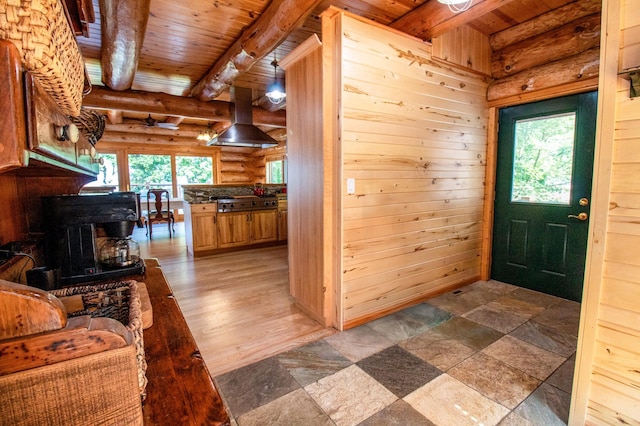 entryway with beam ceiling, wood-type flooring, rustic walls, and wooden ceiling