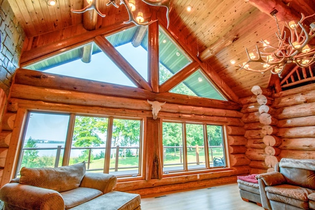 living room with an inviting chandelier, light hardwood / wood-style flooring, high vaulted ceiling, and beamed ceiling