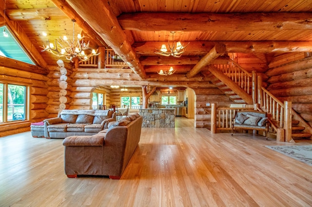 unfurnished living room featuring wood ceiling, a notable chandelier, light wood-type flooring, rustic walls, and beam ceiling