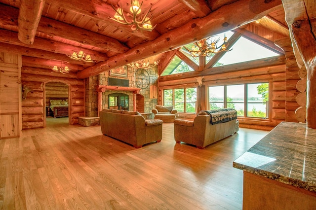 living room with beam ceiling, log walls, and light hardwood / wood-style flooring