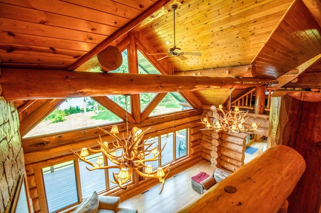 interior details featuring hardwood / wood-style flooring, wooden ceiling, rustic walls, ceiling fan with notable chandelier, and beamed ceiling