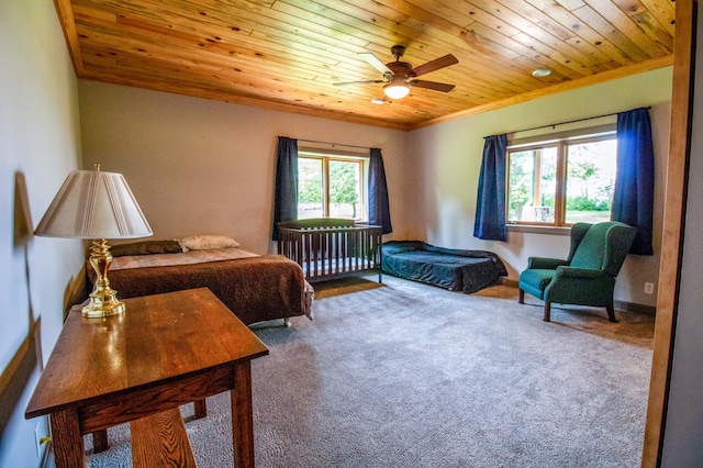 carpeted bedroom featuring ceiling fan, ornamental molding, wood ceiling, and multiple windows