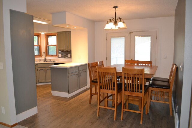 dining space featuring sink, hardwood / wood-style floors, a wealth of natural light, and a notable chandelier