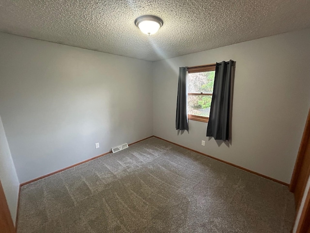 carpeted empty room featuring a textured ceiling