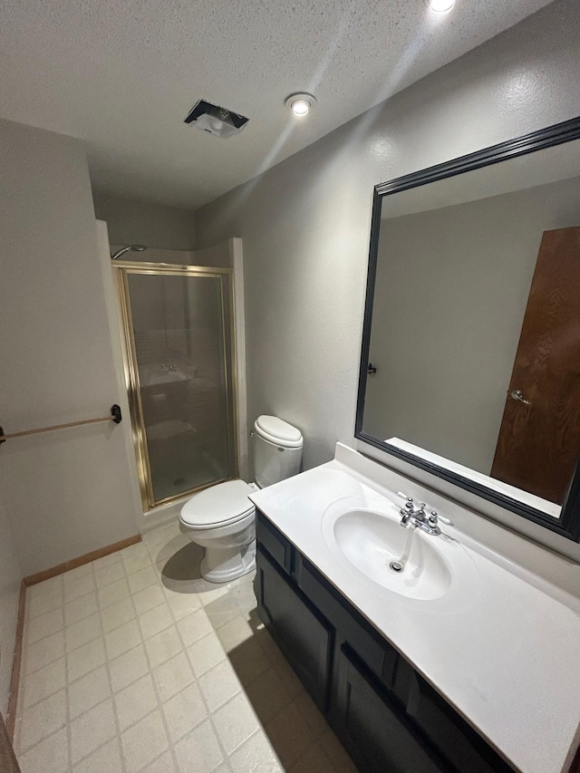 bathroom featuring a textured ceiling, a shower with door, vanity, and toilet