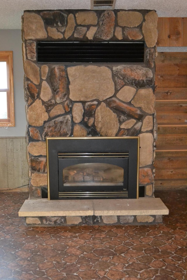 details featuring a fireplace, wood walls, and a textured ceiling