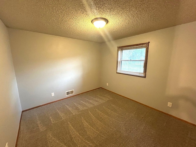 carpeted empty room with a textured ceiling