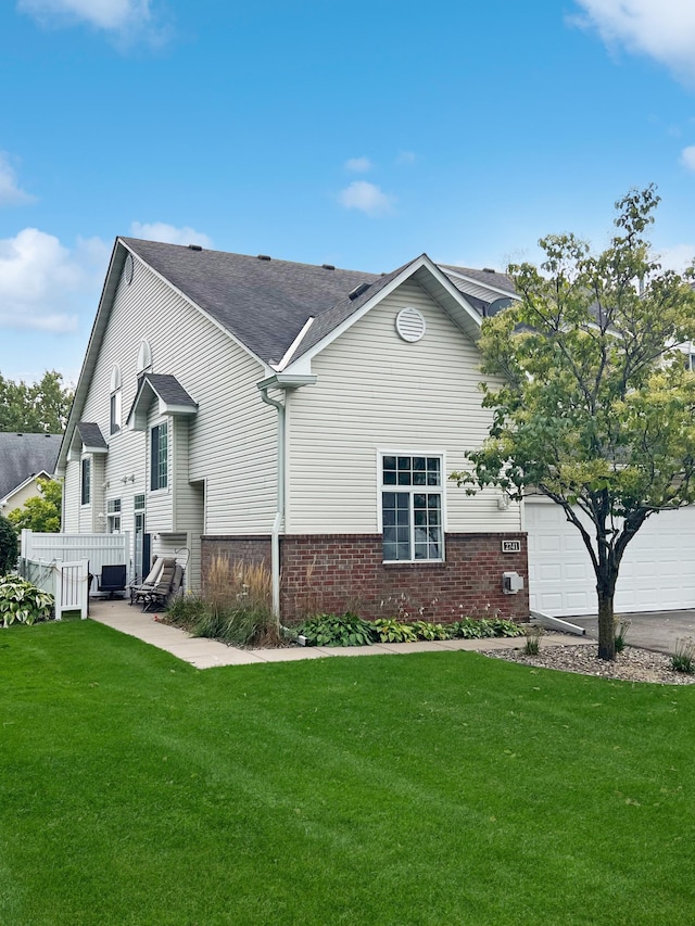 rear view of property with a garage and a yard