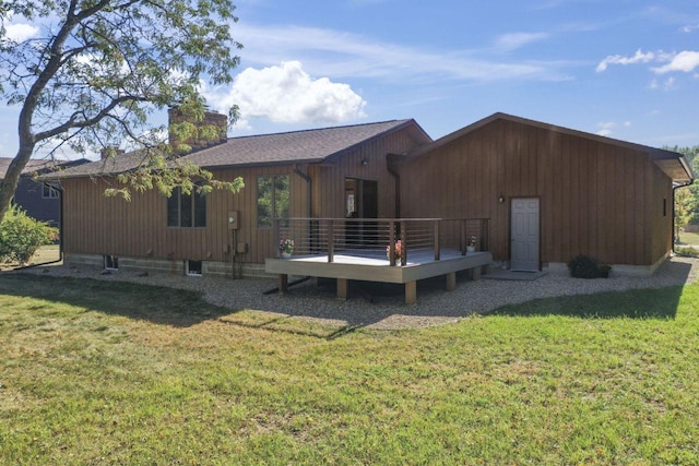 rear view of house with a yard and a wooden deck