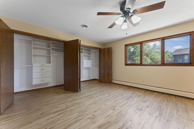 unfurnished bedroom with light hardwood / wood-style floors, a textured ceiling, a baseboard radiator, and ceiling fan