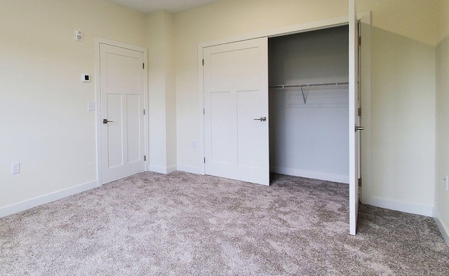 unfurnished bedroom featuring a closet and light colored carpet