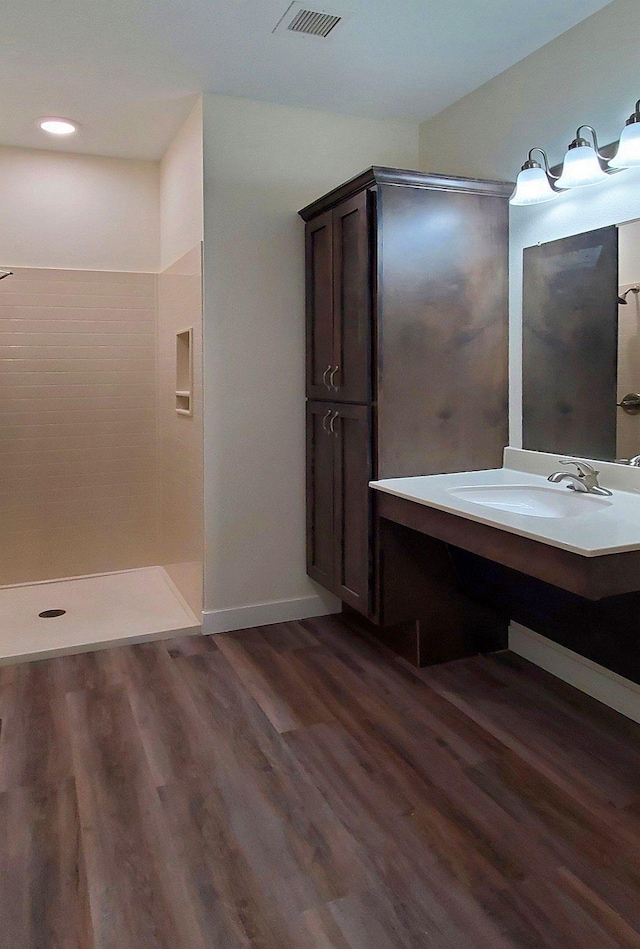 bathroom with vanity, hardwood / wood-style flooring, and a shower