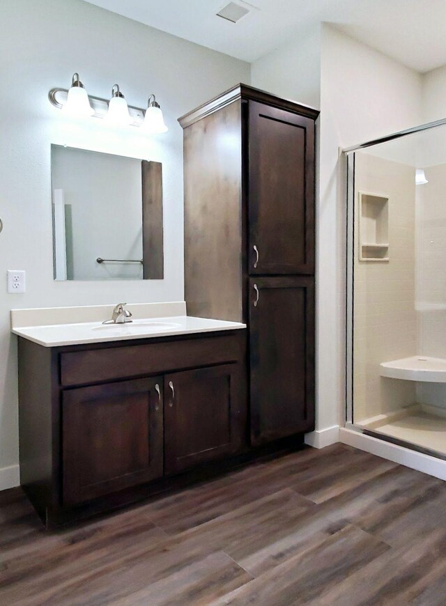 bathroom featuring vanity, hardwood / wood-style floors, and a shower with door