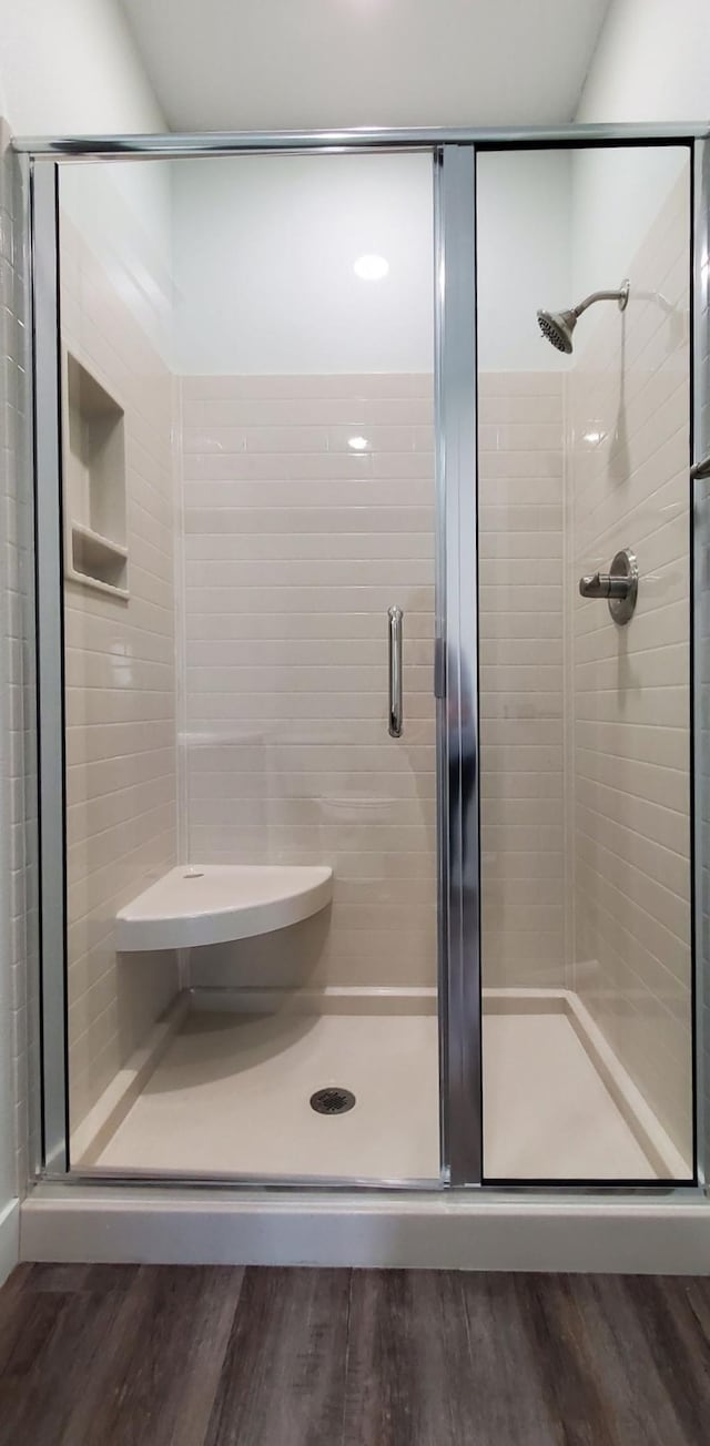 bathroom featuring hardwood / wood-style flooring and an enclosed shower