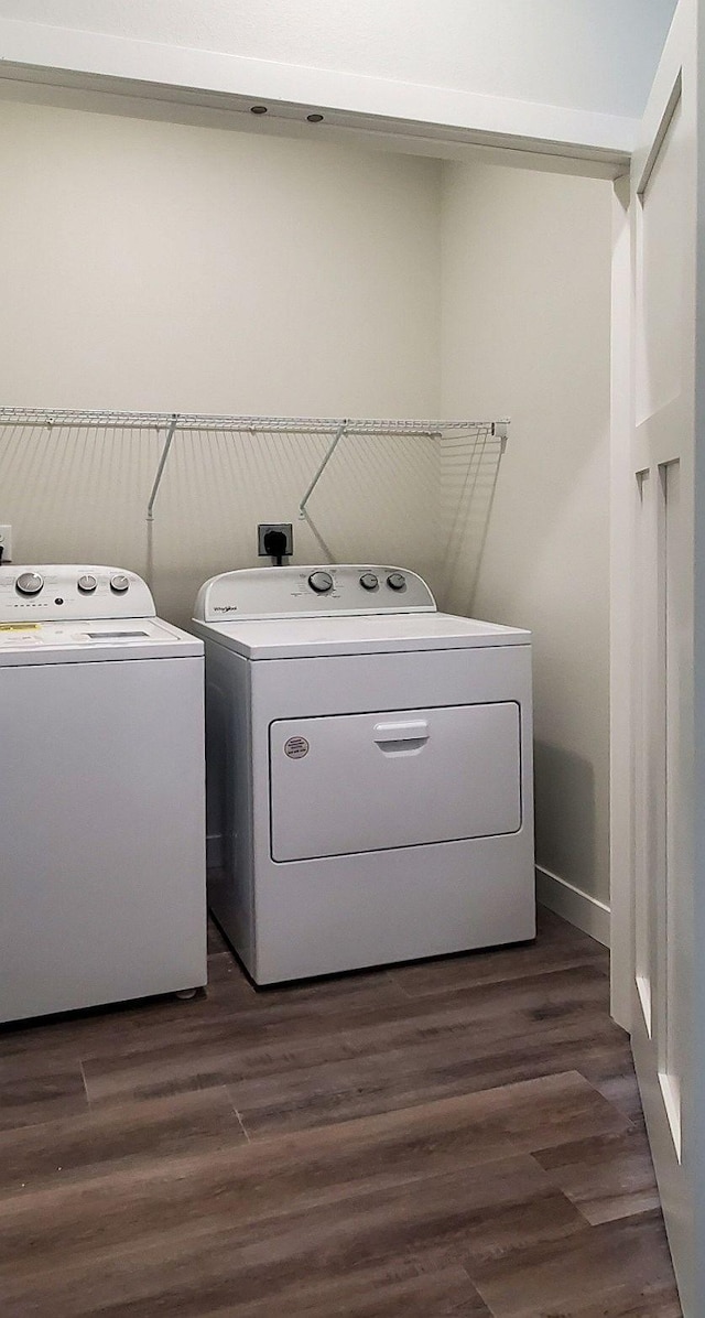 clothes washing area featuring dark wood-type flooring and washing machine and clothes dryer