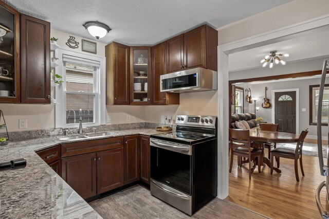 3509 43rd Ave S, Minneapolis, MN 55406 - kitchen featuring stainless steel appliances, light wood-type flooring, healthy amount of natural light, glass insert cabinets, and a textured ceiling