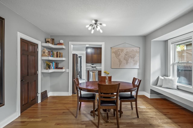 3509 43rd Ave S, Minneapolis, MN 55406 - dining space with a chandelier, light wood-style floors, and a textured ceiling