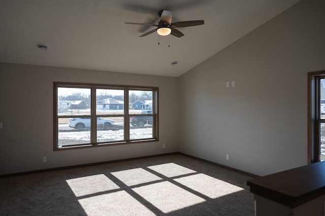 unfurnished room with lofted ceiling, ceiling fan, and dark colored carpet