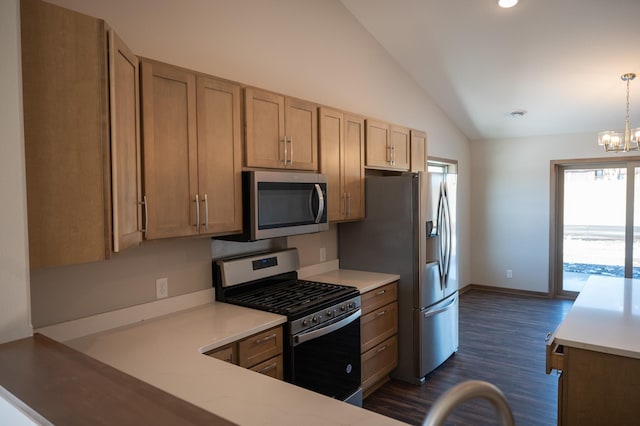 kitchen featuring lofted ceiling, hanging light fixtures, dark hardwood / wood-style flooring, a notable chandelier, and stainless steel appliances