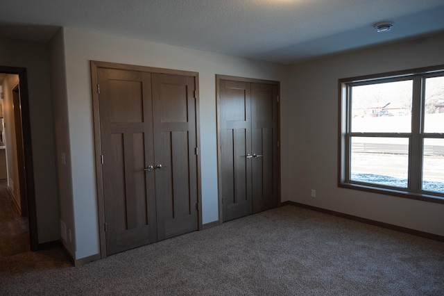 unfurnished bedroom with multiple closets, multiple windows, and carpet