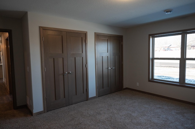 2218 Red Bird Ln, Fairmont, MN 56031 - unfurnished bedroom featuring multiple closets and carpet flooring