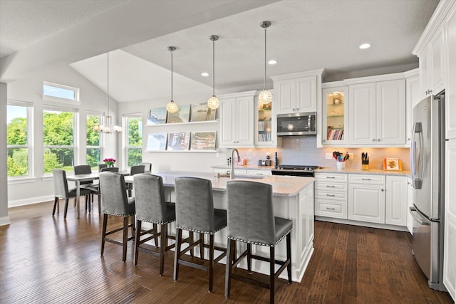 kitchen with white cabinetry, stainless steel appliances, and vaulted ceiling