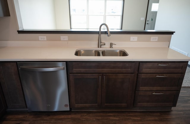 kitchen with sink, dark brown cabinets, dark hardwood / wood-style floors, and dishwasher