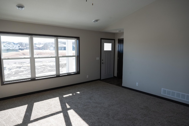 carpeted empty room with lofted ceiling