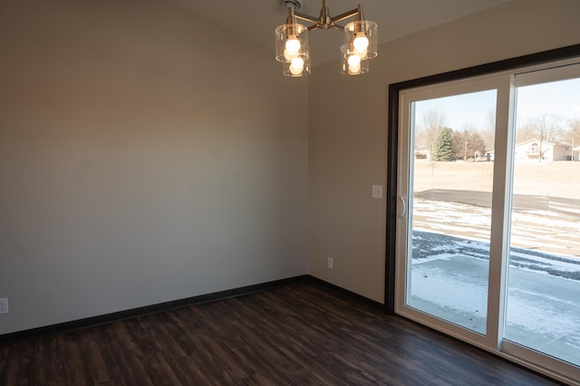 spare room with a notable chandelier and dark hardwood / wood-style flooring