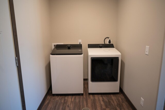 laundry area with washer and dryer and dark wood-type flooring