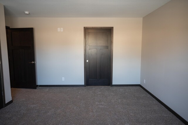 unfurnished bedroom featuring dark carpet