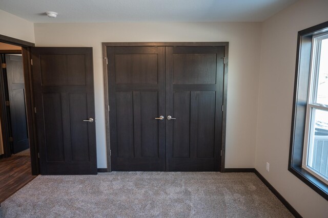 unfurnished bedroom featuring light colored carpet and a closet