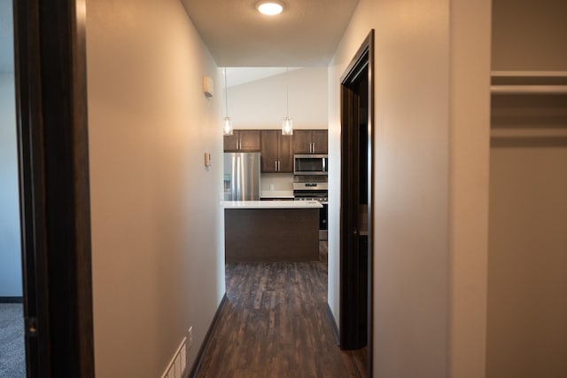 corridor with lofted ceiling and dark hardwood / wood-style flooring