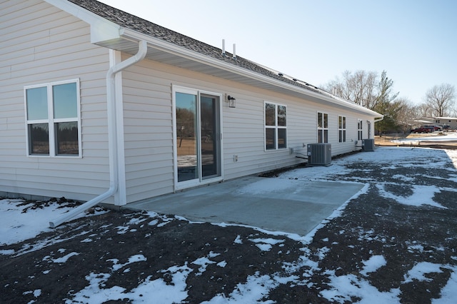 snow covered property with central AC