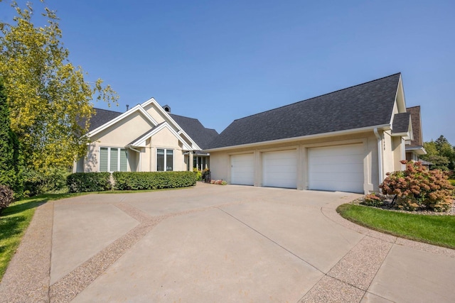 17680 Bearpath Trl, Eden Prairie, MN 55347 - view of front facade featuring concrete driveway, a garage, stucco siding, and a shingled roof
