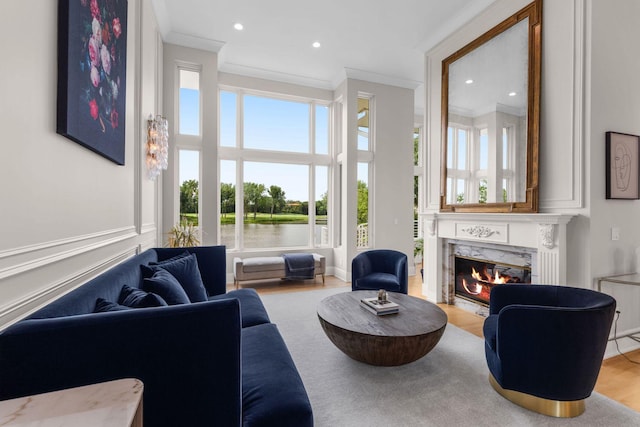 17680 Bearpath Trl, Eden Prairie, MN 55347 - living area featuring ornamental molding, a high end fireplace, plenty of natural light, wood finished floors, and a water view