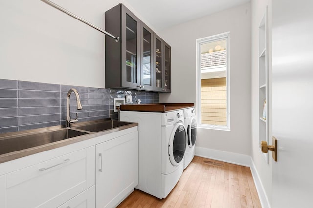 17680 Bearpath Trl, Eden Prairie, MN 55347 - laundry room with washing machine and clothes dryer, cabinet space, plenty of natural light, and light wood-type flooring