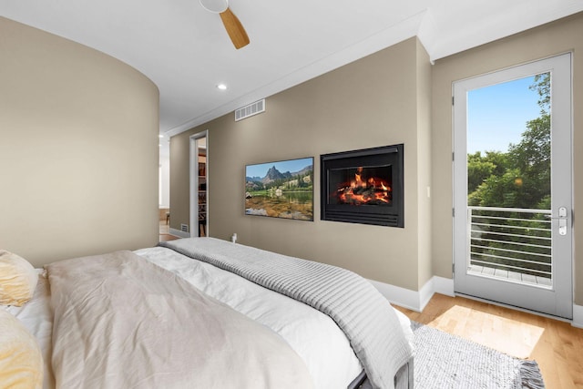 17680 Bearpath Trl, Eden Prairie, MN 55347 - bedroom featuring access to exterior, wood finished floors, a warm lit fireplace, recessed lighting, and a ceiling fan