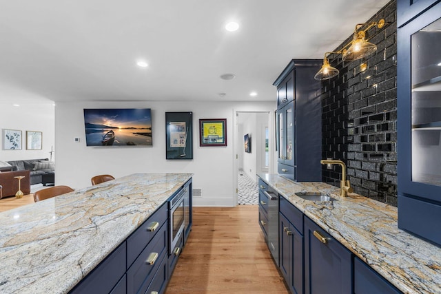 17680 Bearpath Trl, Eden Prairie, MN 55347 - kitchen with stainless steel microwave, light wood-style flooring, recessed lighting, light stone counters, and blue cabinetry
