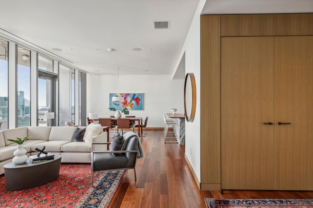 living room featuring dark wood-type flooring and expansive windows