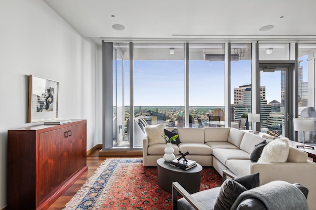 living room with a wall of windows and dark hardwood / wood-style floors