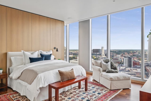 bedroom with floor to ceiling windows, multiple windows, and dark wood-type flooring