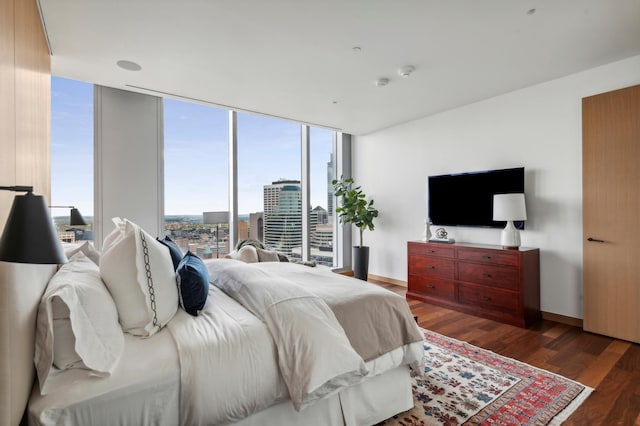 bedroom with floor to ceiling windows, multiple windows, and dark wood-type flooring