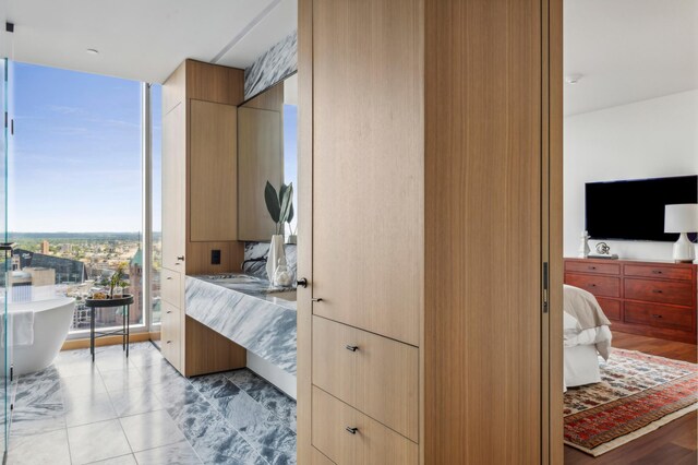 bedroom with a wall of windows and light hardwood / wood-style flooring