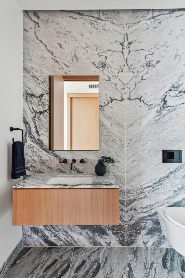 bathroom featuring tile walls, vanity, and toilet