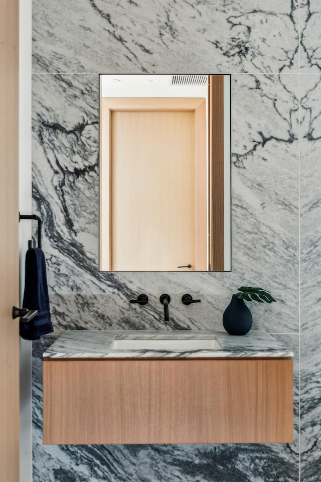 bathroom with vanity and tile walls